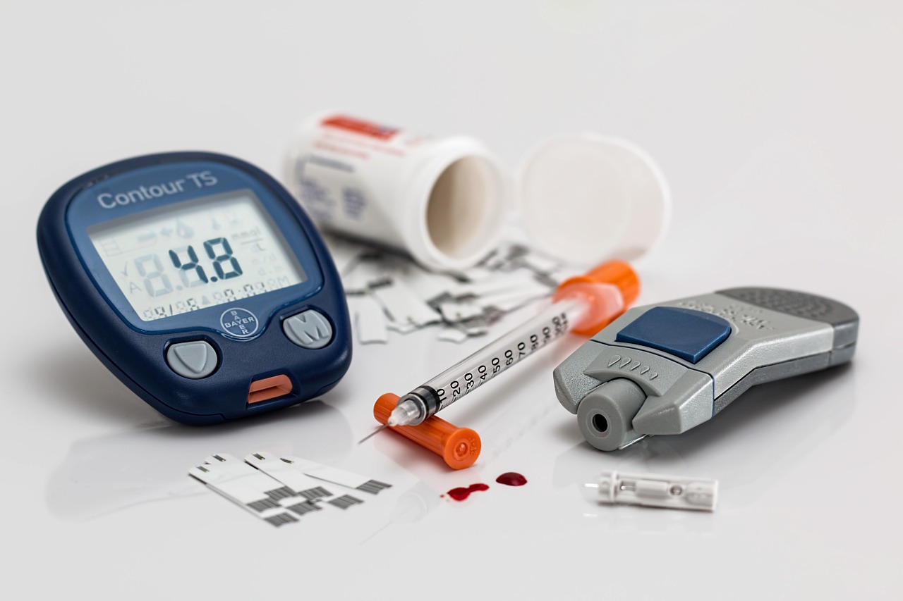 Blutzuckermessgerät, Teststreifen und Insulinspritze als Symbol für Typ-2-Diabetes